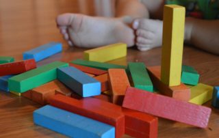 Toddler with building blocks scattered