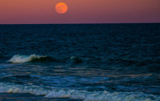 Full Red Moon over the ocean at Surf City 
