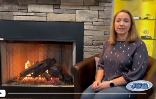 Danielle seated in front of a fireplace