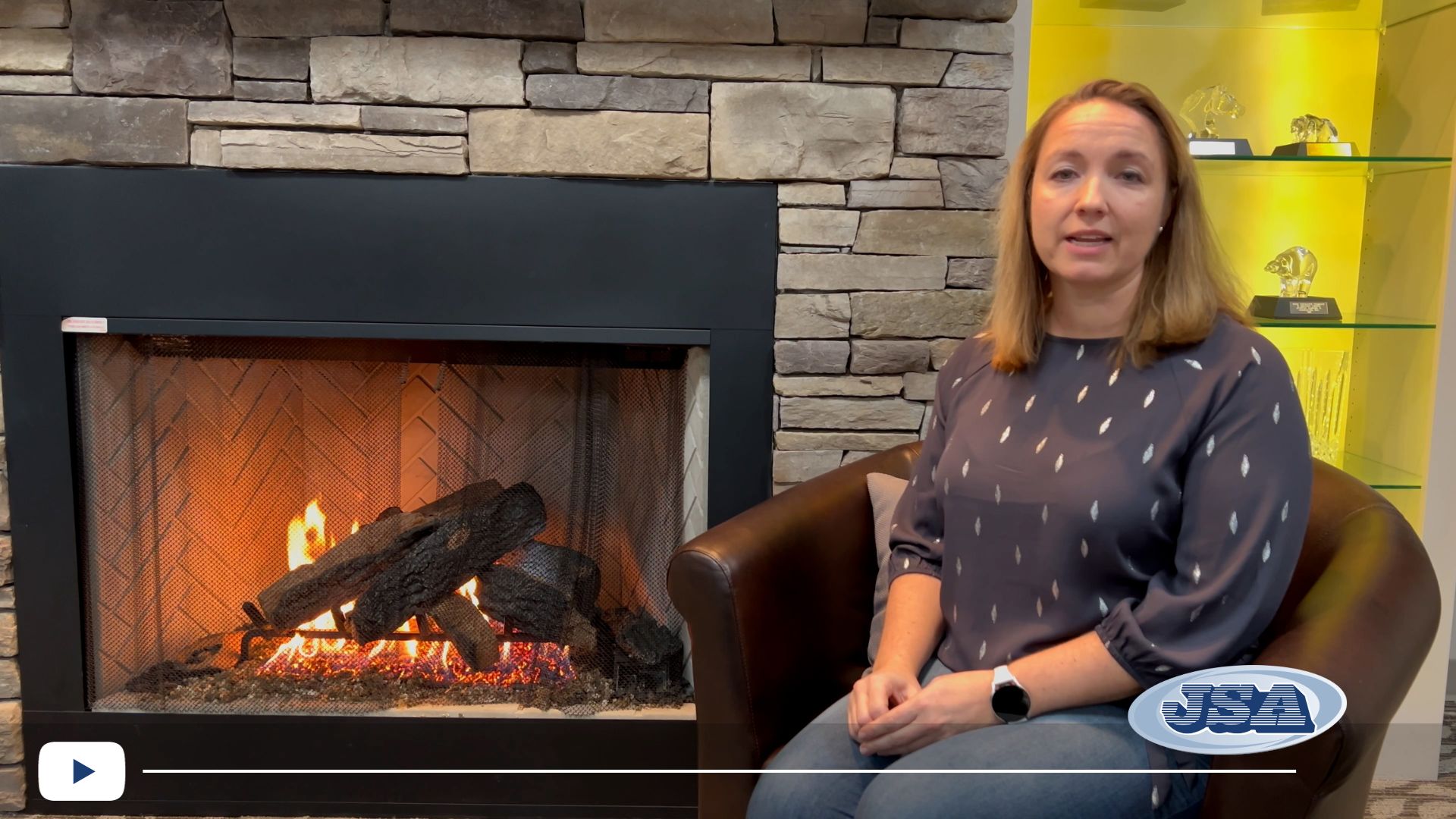 Danielle seated in front of a fireplace