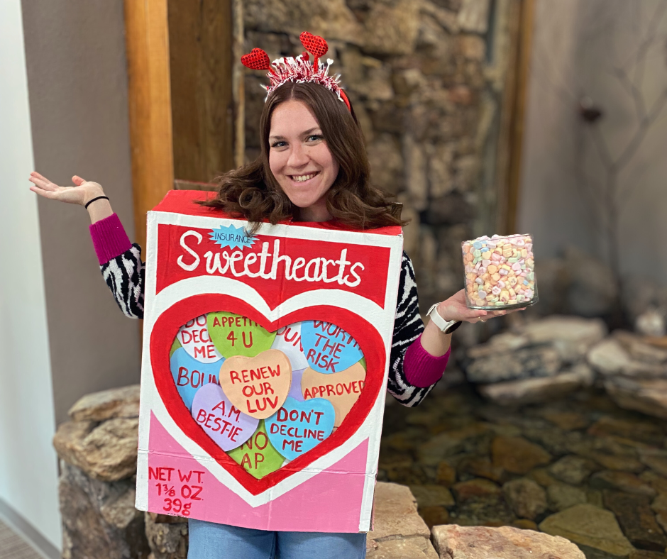 Grace Brown holding a candy jar filled with Red Hots for the Valentine's Day contest